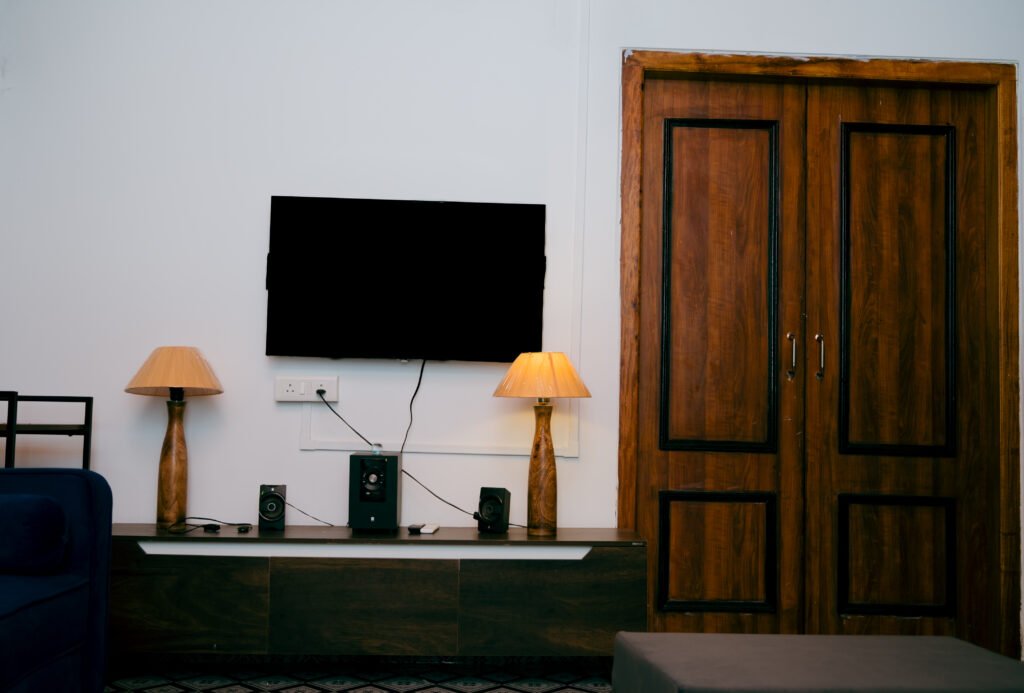 TV setup with two lamps on each side and a door