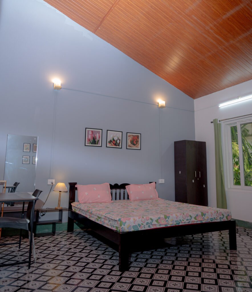 Double bed with a wall painting, bedside lamp, mirror and Wardrobe