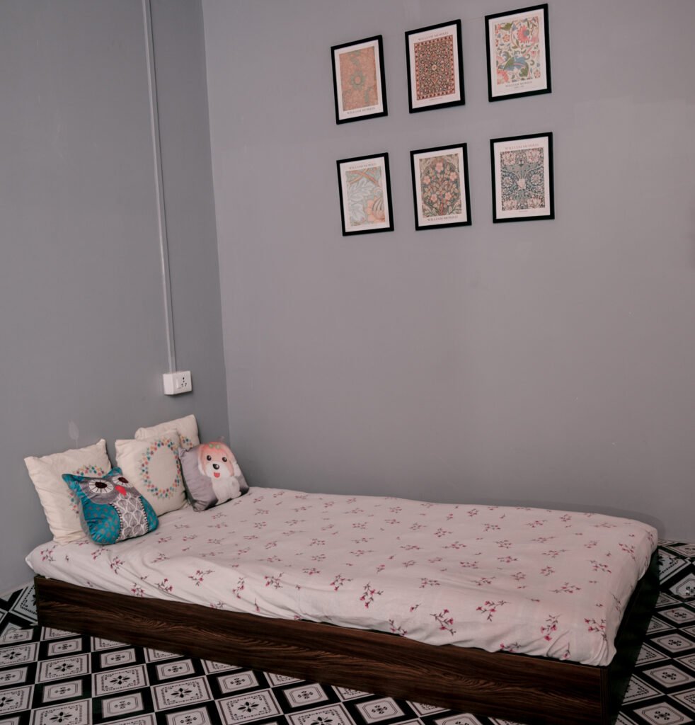Bedroom with one single bed, a wall painting and switch Board